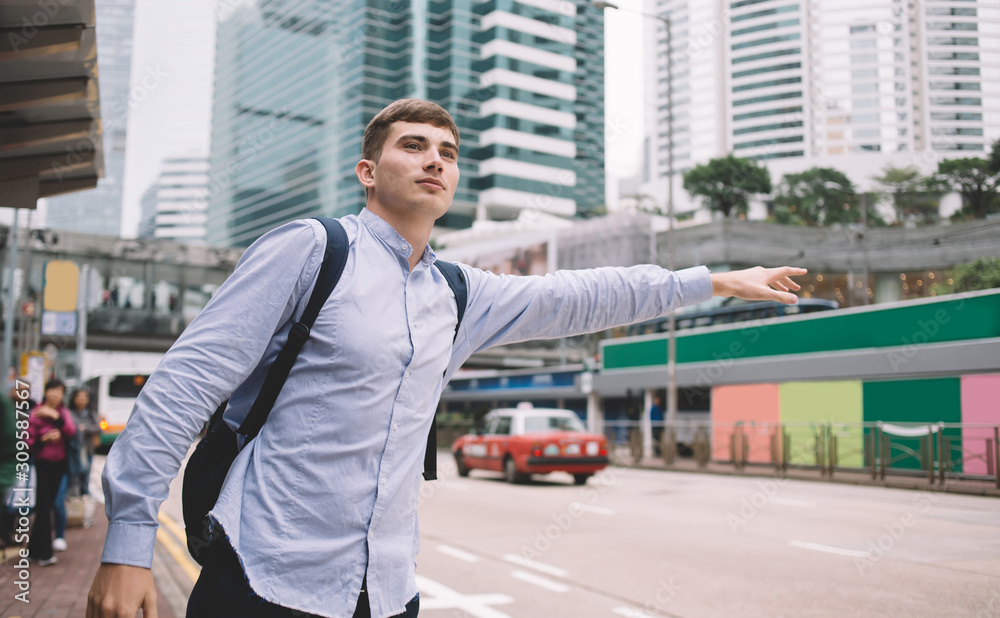 Fair haired student with backpack taking taxi Fair haired student with backpack taking taxi