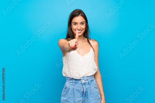 Young woman over isolated blue background showing and lifting a finger photo