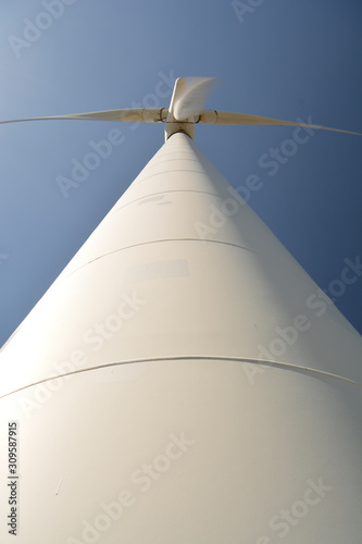 Close-up and low angle view of spinning wind turbine  providing green  low carbon and renewable electricity and energy