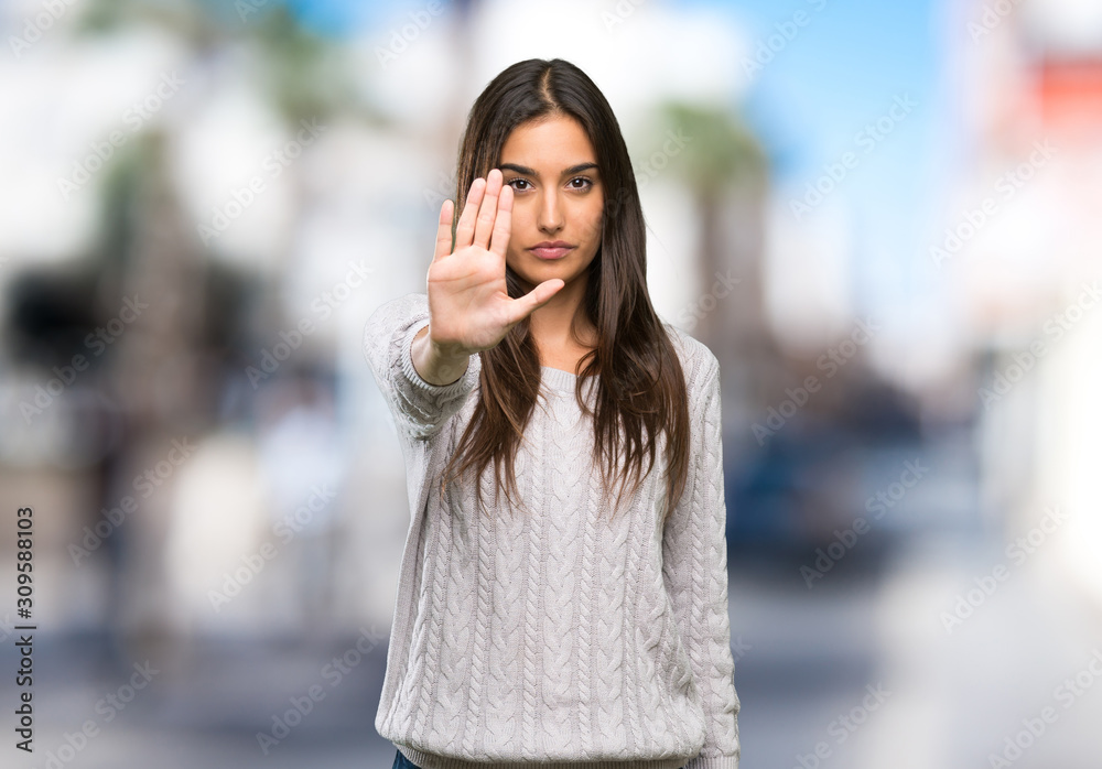 Young hispanic brunette woman making stop gesture at outdoors