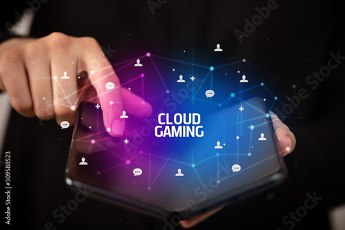 Businessman holding a foldable smartphone with CLOUD GAMING inscription, new technology concept