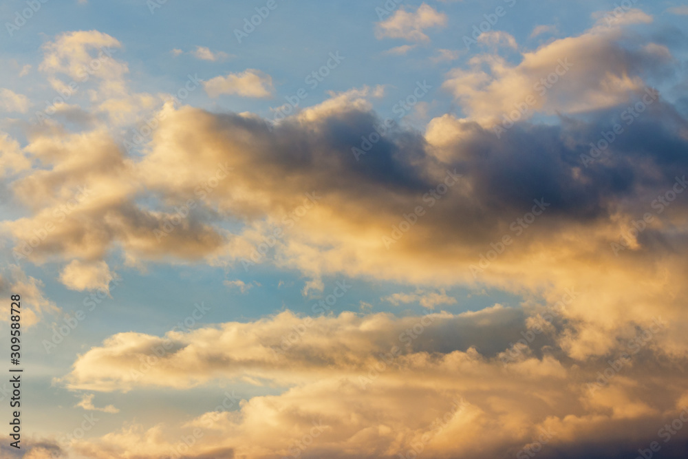 golden clouds on a blue sky at sunset. beautiful nature background. wonderful atmosphere scenery in the evening. cloudy forecast in the evening concept.