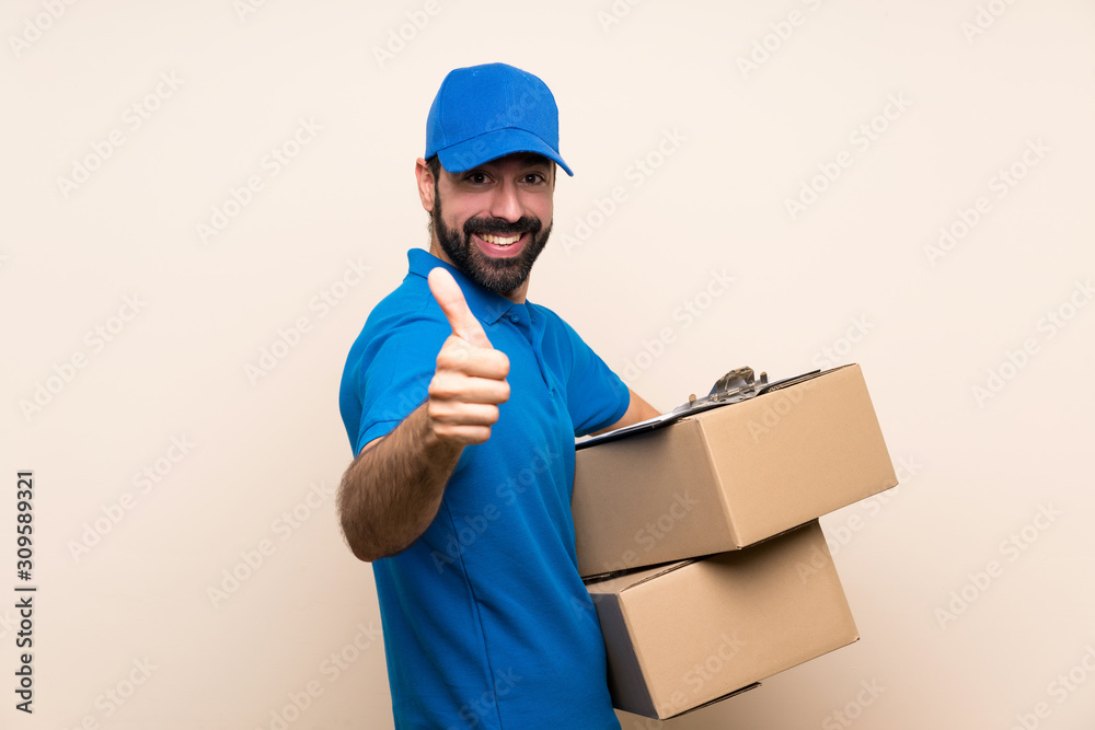 Delivery man with beard over isolated background with thumbs up because something good has happened Delivery man with beard over isolated background with thumbs up because something good has happened