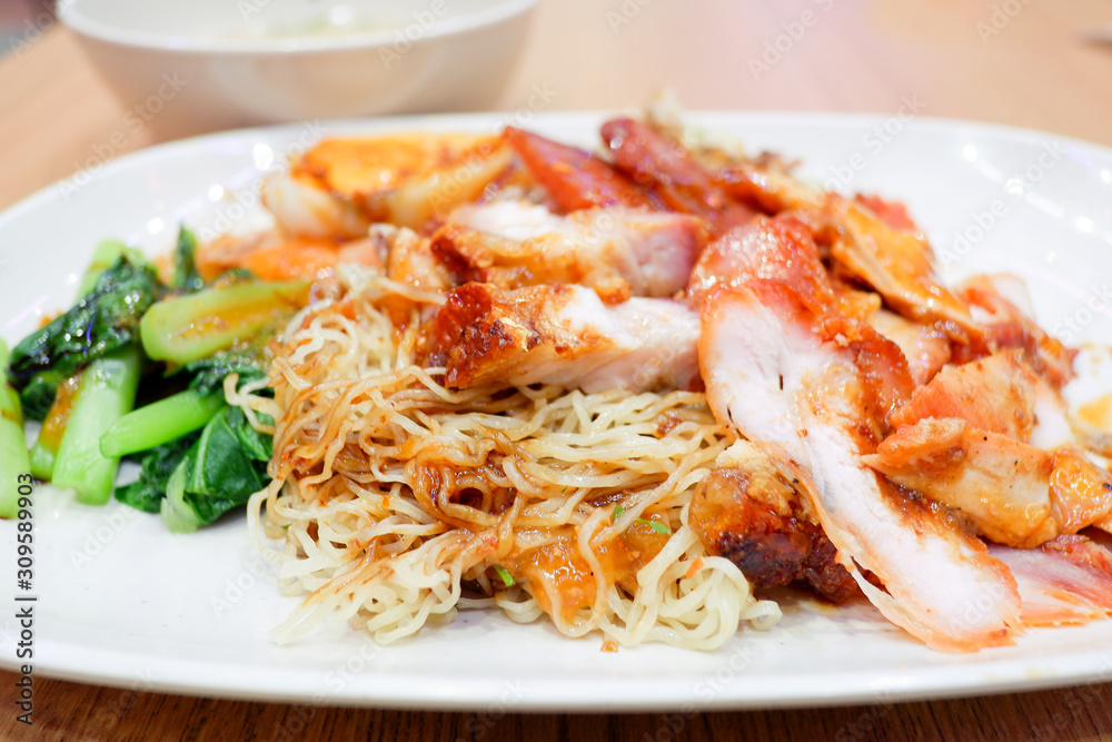 Wantan noodles, a Cantonese Chinese cuisine served dry with soy sauce and roast pork Wantan noodles, a Cantonese Chinese cuisine served dry with soy sauce and roast pork