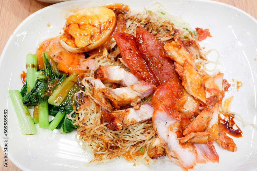 Wantan noodles, a Cantonese Chinese cuisine served dry with soy sauce and roast pork Wantan noodles, a Cantonese Chinese cuisine served dry with soy sauce and roast pork