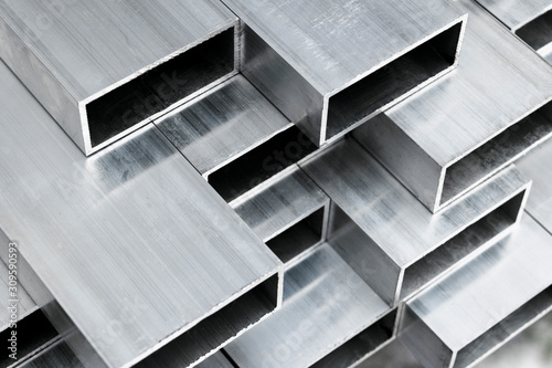 Aluminium profile for windows and doors manufacturing. Structural metal aluminium shapes. Aluminium profiles texture for constructions. Aluminum constructions factory background. © Aleksei
