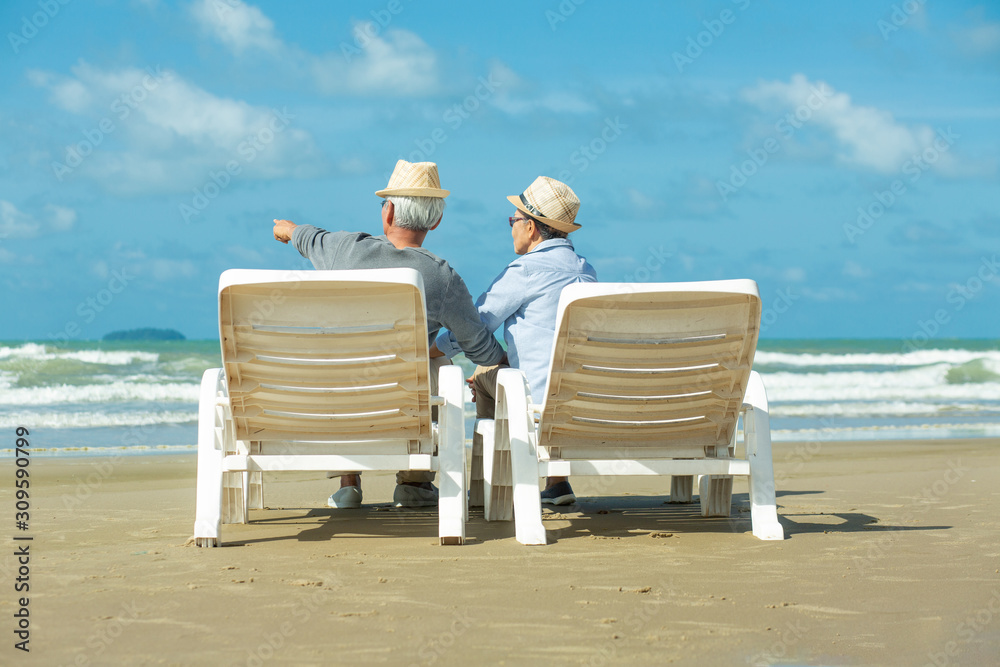 Romantic of senior couple sitting in deckchair on the beach together near sea.Love is everything, Retirement age concept and love.
