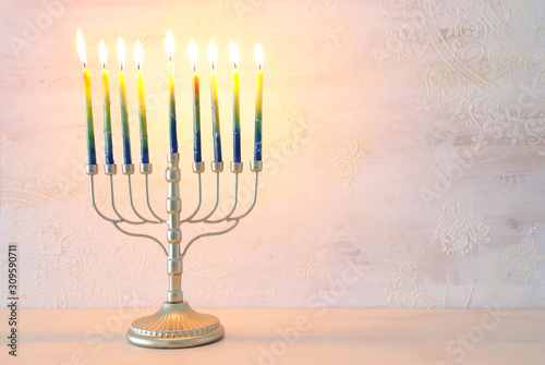 Religion image of jewish holiday Hanukkah background with brass menorah (traditional candelabra) and candles
