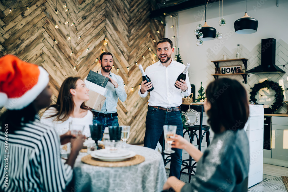 Excited men carrying bottles of champagne to table Excited men carrying bottles of champagne to table