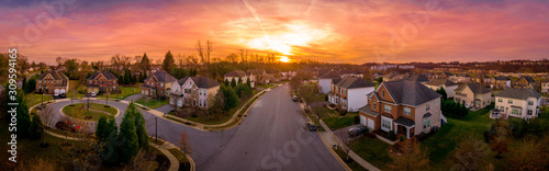 Aerial sunset panorama view of cul-de-sac  dead-end  luxury upscale residential neighborhood gated community street in Maryland USA  American real estate with single family homes brick facade 
