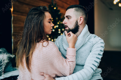 Fotografie Young couple enjoying time together with Christmas tree on background