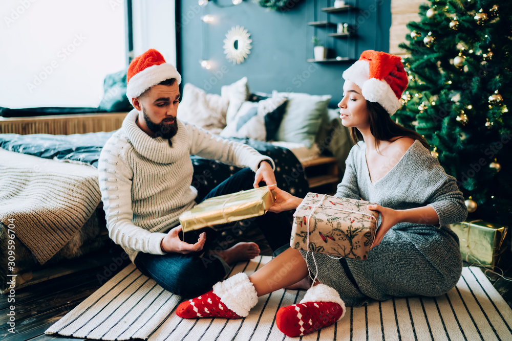 Fototapeta premium Man and woman exchanging Christmas gifts