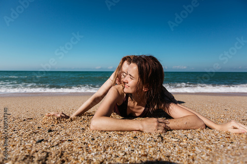 Two young cheerful girlfriends women lie together on the seashore. © kazantsevaov