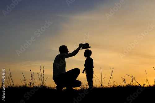 silhouette of father and son play on sunset