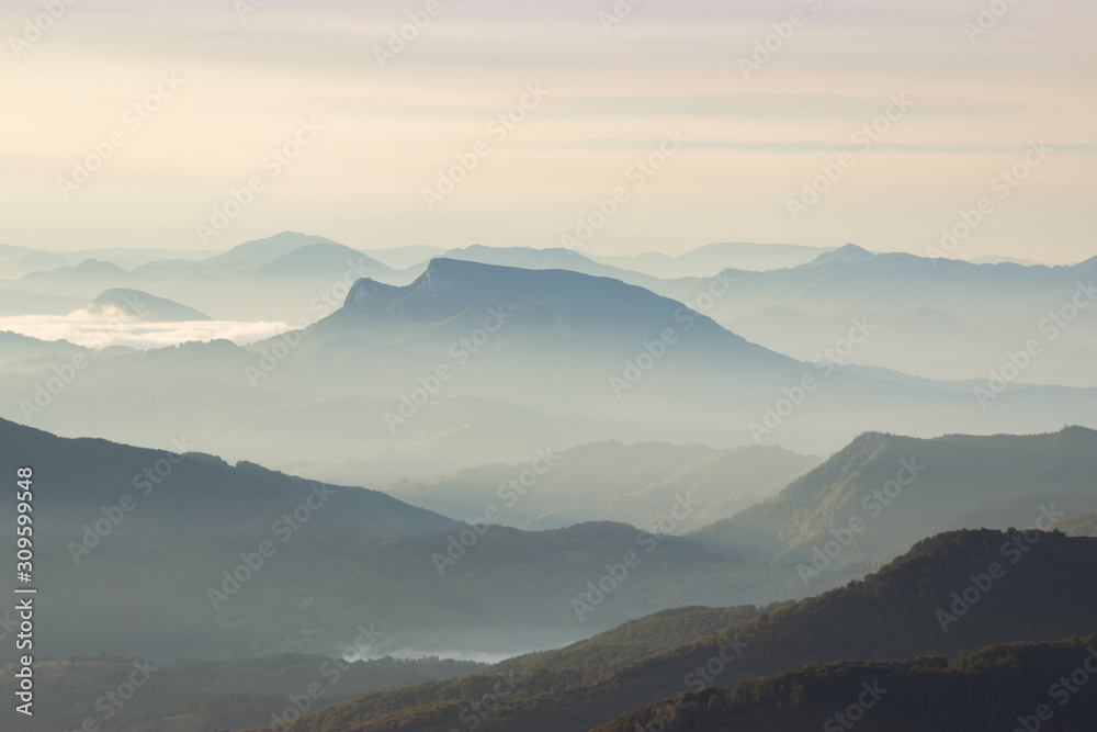 Mountains landscape layers mist in the morning fog