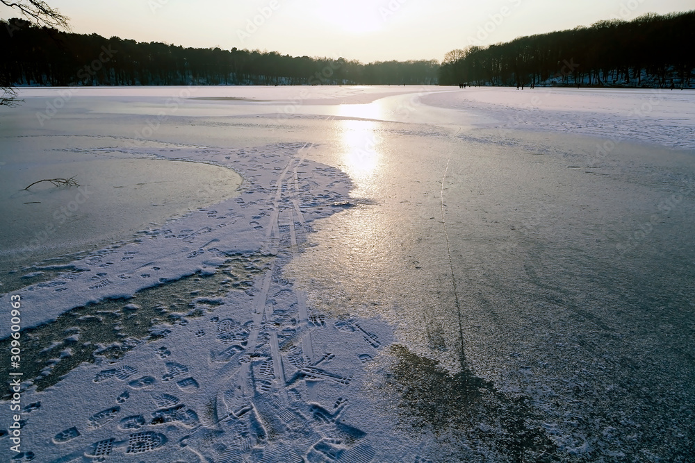 See mit Eisfläche mit verschleiertem Sonnenlicht im Hintergrund Stock