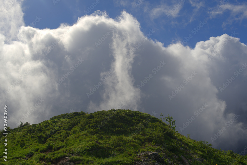 view from a mountain of clouds rising over a mountain