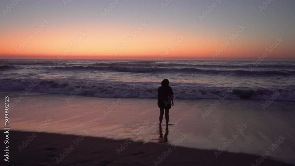 Woman on the beach at sunset