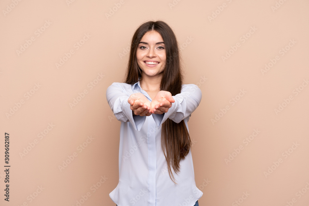 Young woman over isolated background holding copyspace imaginary on the palm to insert an ad Young woman over isolated background holding copyspace imaginary on the palm to insert an ad