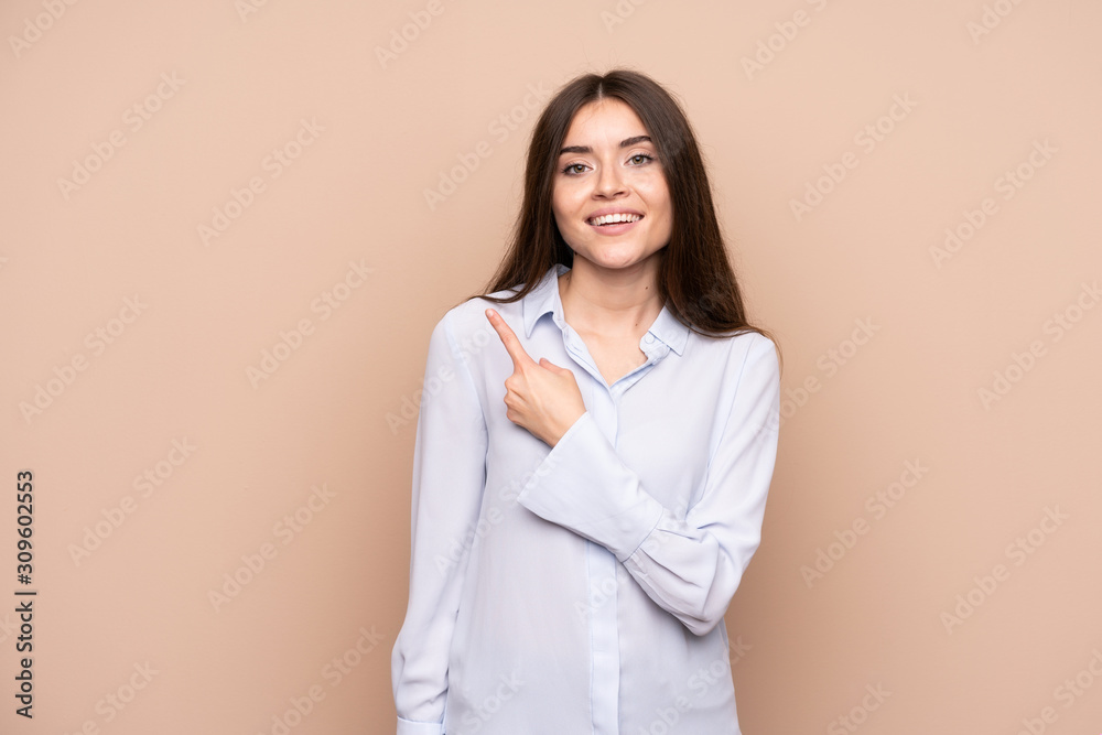 Young woman over isolated background pointing to the side to present a product Young woman over isolated background pointing to the side to present a product