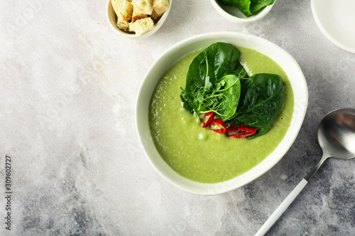 Vegetarian Green diet cream soup with broccoli and spinach, croutons on a marble gray background. Image with horizontal orientation and copy space, top view