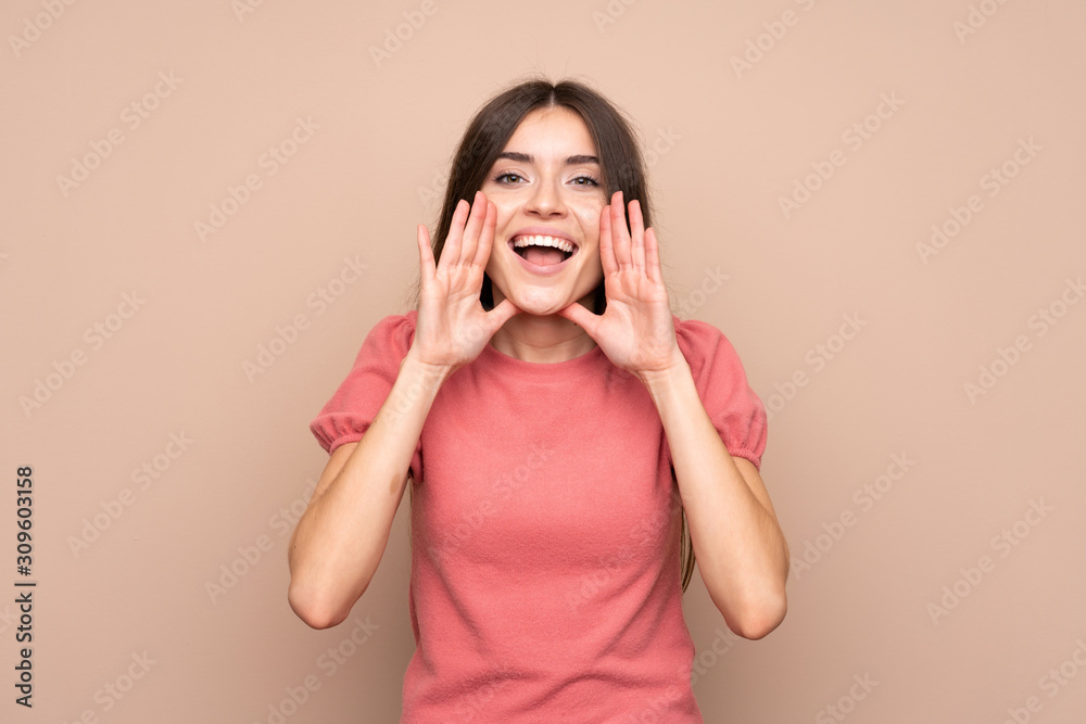 Young woman over isolated background shouting with mouth wide open Young woman over isolated background shouting with mouth wide open
