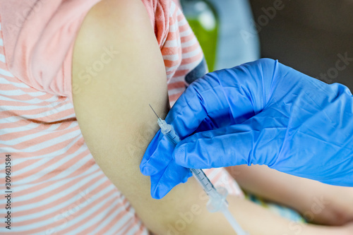 close-up. the doctor in blue gloves gives an injection. baby  hand is almost ready for an injection.