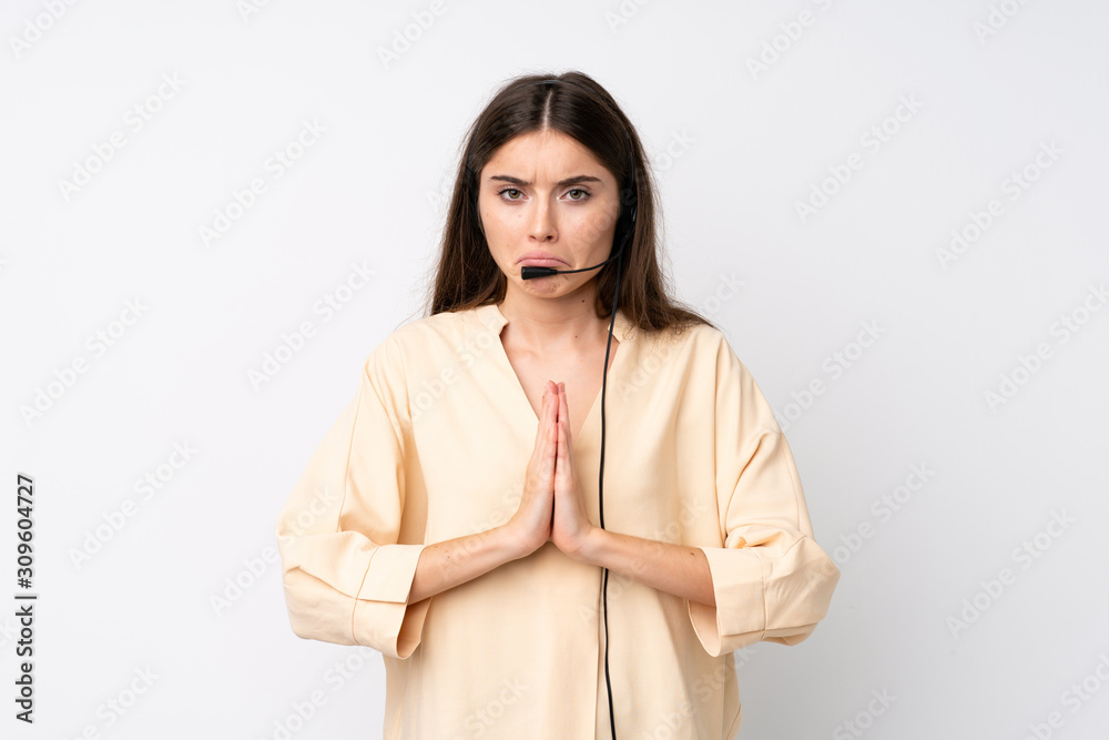 Young telemarketer woman over isolated white background pleading Young telemarketer woman over isolated white background pleading