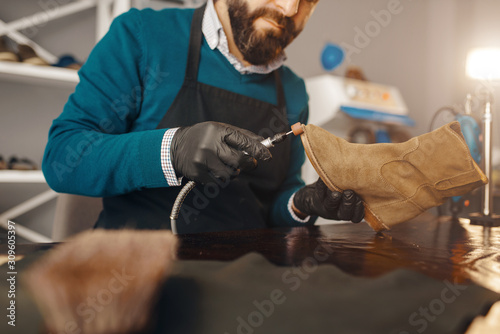 Papier peint Shoemaker sharpens the shoe sole, footwear repair