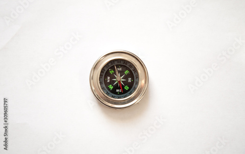 Compass in a metal frame on a white background. View from above.