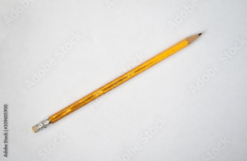 Old yellow pencil. Sharpened with erasure. White background.