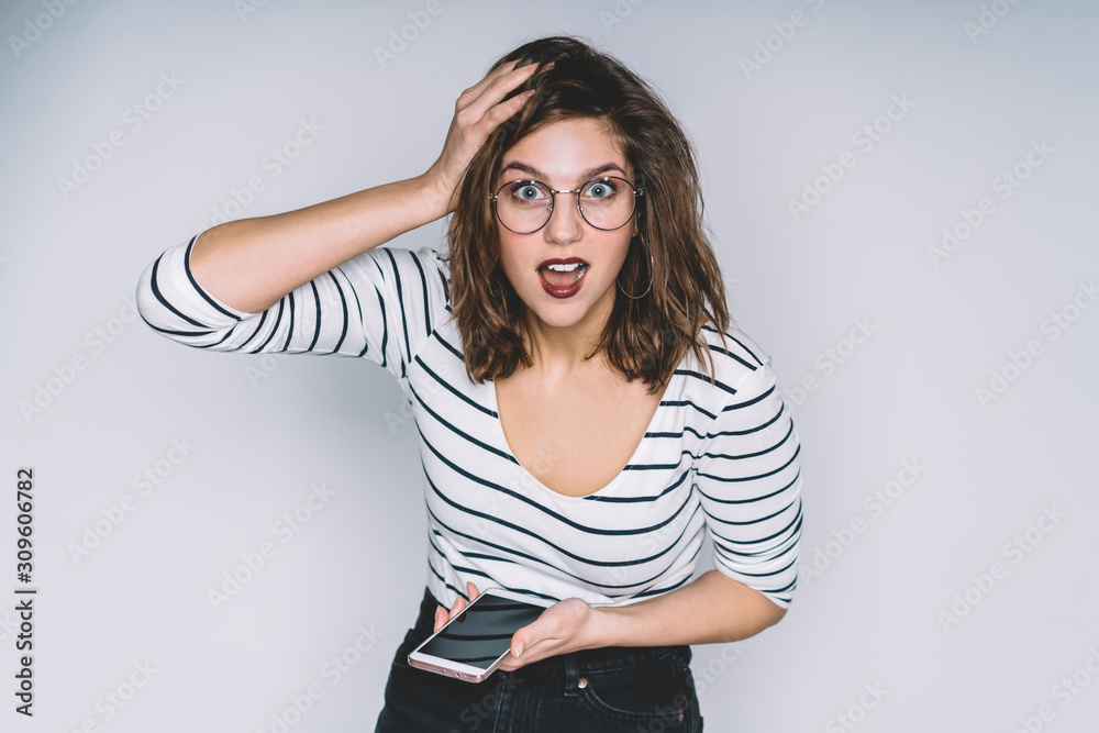Surprised young beautiful woman surfing mobile in studio Surprised young beautiful woman surfing mobile in studio
