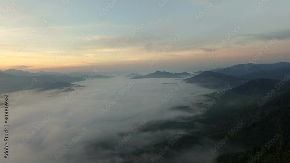 Aerial view mountains
covered forest trees in clouds and fog the sky and mountains morning. Slopes of mountains with evergreen vegetation. Mountainous tropical landscape.Southern of Thailand. Aerial view mountains
covered forest trees in clouds and fog the sky and mountains morning. Slopes of mountains with evergreen vegetation. Mountainous tropical landscape.Southern of Thailand.