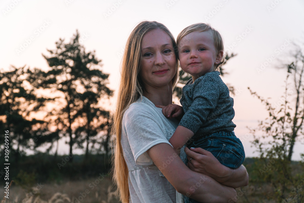 Fototapeta premium Family portrait of mother and her young son in the park. Family leisure outdoors in the natural landscape