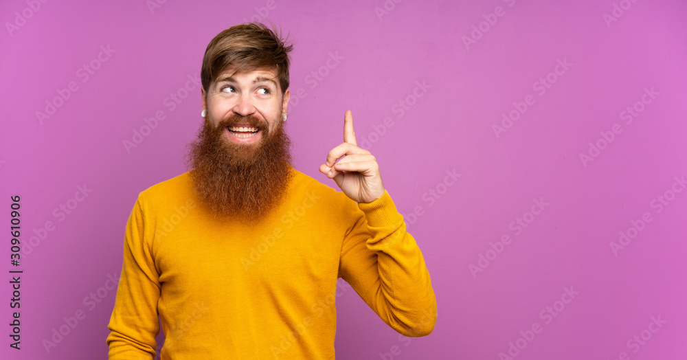 Redhead man with long beard over isolated purple background intending to realizes the solution while lifting a finger up Redhead man with long beard over isolated purple background intending to realizes the solution while lifting a finger up