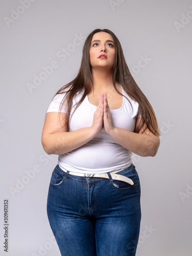 Plus Size Model with long hair posing in studio. be at one's de photo