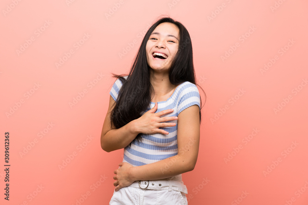 Obraz premium Teenager asian girl over isolated pink background smiling a lot