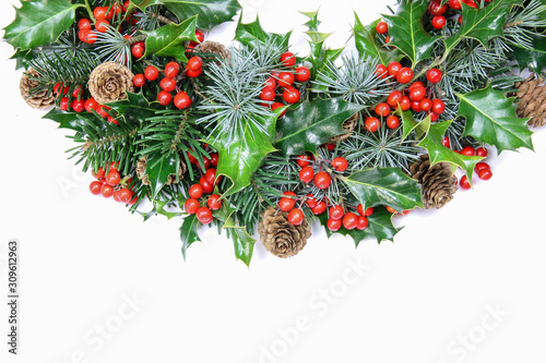 Colourful traditional Christmas wreath with natural fresh holly to celebrate the holiday season isolated on white with copy space