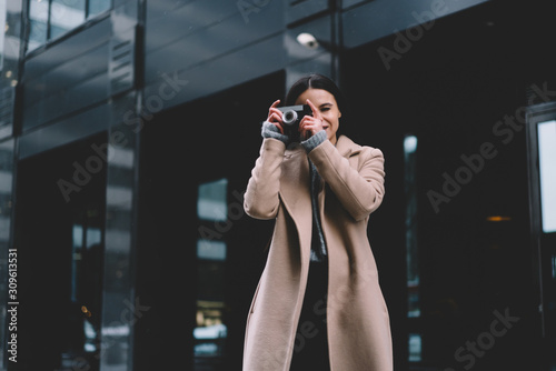 Trendy woman taking photo on street
