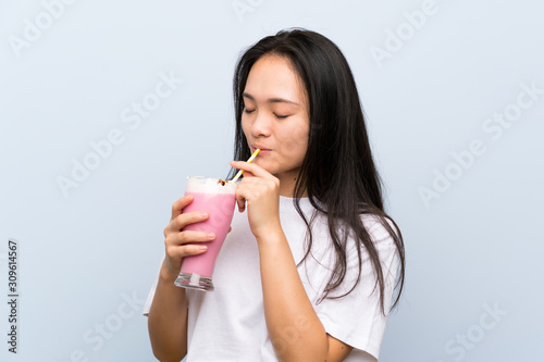 Teenager asian girl holding a strawberry milkshake