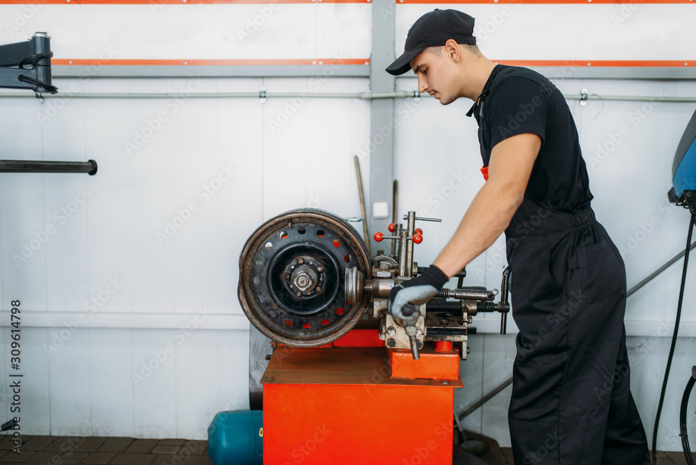 Repairman works with crumpled disc, tire service Repairman works with crumpled disc, tire service