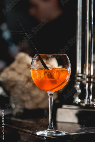 glass of refreshing orange alcoholic cocktail on a table in the bar