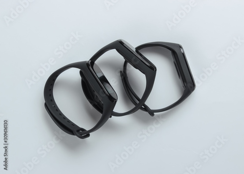Three smart bracelets on a white background. Modern gadgets for sports and everyday activities