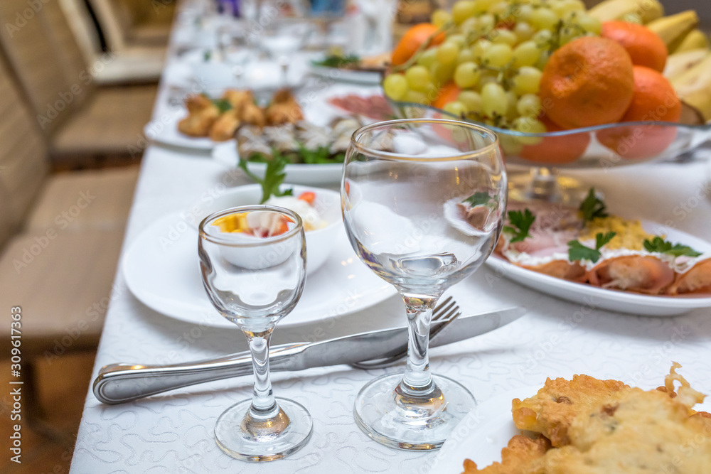 banquet table served with instruments and decorated with empty wine glasses banquet table served with instruments and decorated with empty wine glasses