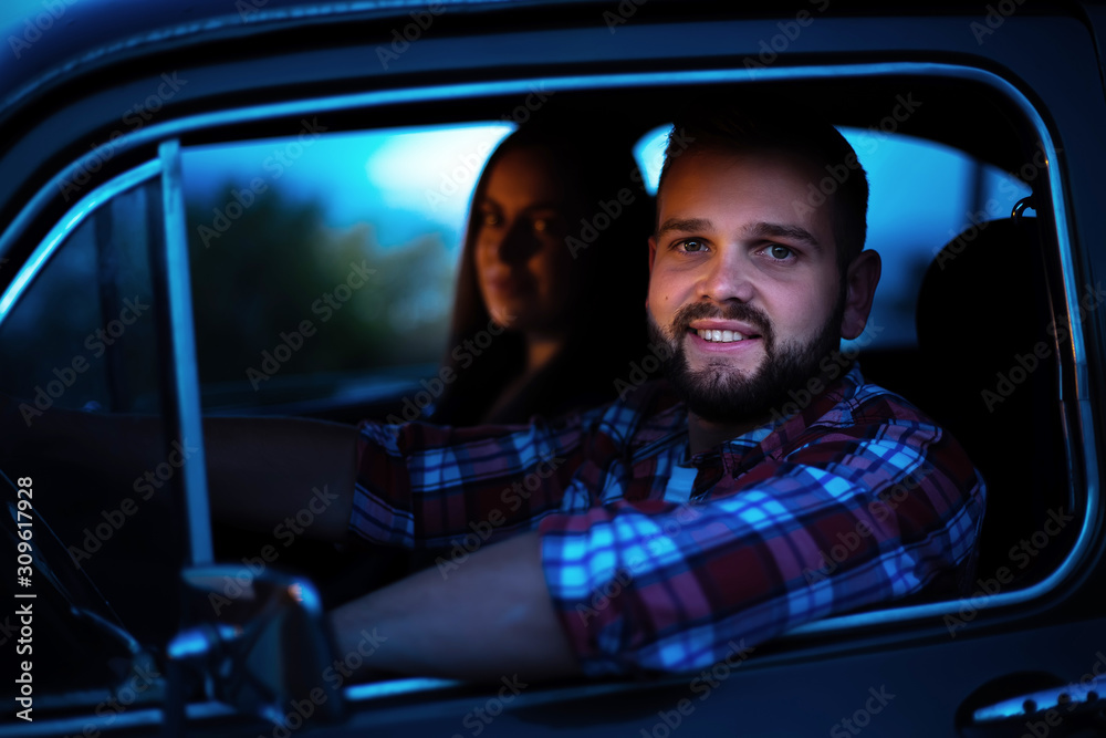 Obraz premium Portrait of a young man who sitting in an old car