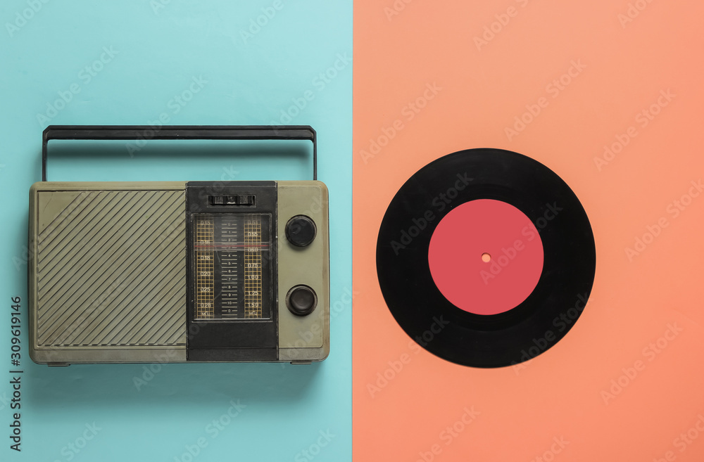Fototapeta premium FM radio receiver, vinyl record on pink, blue background. Music lover concept. Top view. 70s