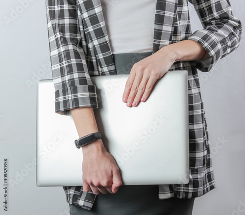 Business business woman in formal clothes holds a laptop while standing on a white background. Crop photo. Office worker © splitov27
