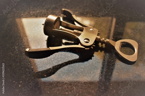 Metal cork screw on black ground with reflection