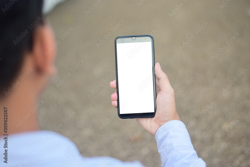 close up hand holding smart phone and white screen outdoor over blured background, mobile phone concept.