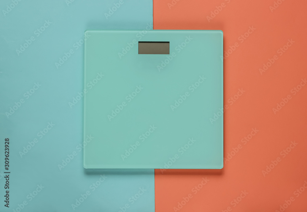 Floor scales on a blue-pink pastel background. The concept of losing weight. Studio shot. Top view Floor scales on a blue-pink pastel background. The concept of losing weight. Studio shot. Top view